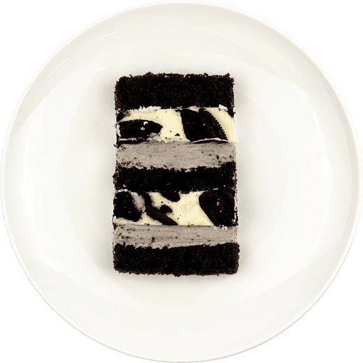 Шматочок торту з двошаровою начинкою орео-чизкейк на тарілці.